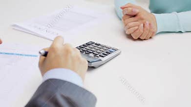 Woman and realtor counting on calculator