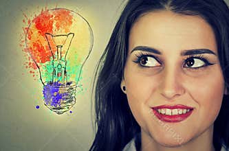 Woman with bright idea light bulb looking sideways
