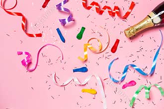 Flat lay of Celebration. Champagne bottle with colorful party st