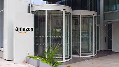 Street signage board with Amazon. com logo. Modern office building. Editorial 4K 3D rendering