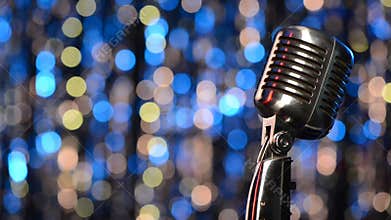 Closeup of retro microphone with blurred lights at background