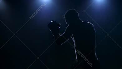 Right hook. Workout boxer in the dark studio. Slow motion