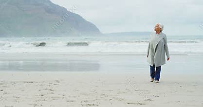 Senior woman walking on beach