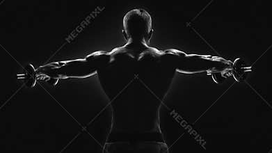 Black and white image of dumbbell lateral raise routine Bodybuilder turning back raising hands pumping up shoulders muscle