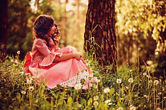 Child girl dressed as fairytale princess in summer forest