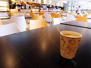 Cafeteria table with cup of hot coffee