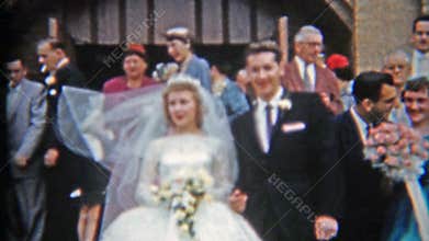 DETROIT, MICHIGAN 1957: Newlywed couple leaving church kissing and celebration.