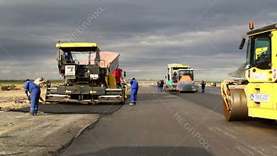 Tracked paver laying fresh asphalt pavement,time lapse
