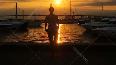 Girl is back in sunglasses at sunset in summer
