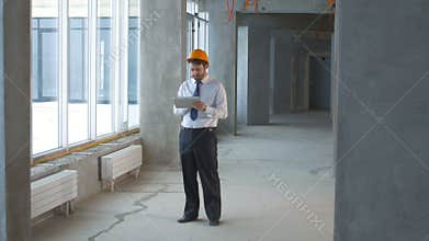 Construction engineer, businessman, realtor inside a new building inspecting construction site using tablet.