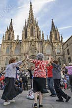 People dancing in front of Holy Cross Cathedral in Barcelona, Sp