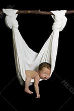 Newborn sleeping peacefully in white hammock