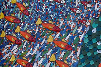 Orange fish stand out in bold blue and green mosaic wall