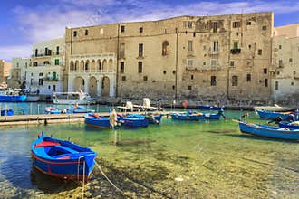 Old port of Monopoli province of Bari, region of Apulia, southern Italy: view of the old town with fishing and rowing boats, Italy