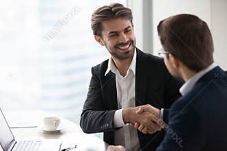 Satisfied happy businessman in suit handshake business partner making deal