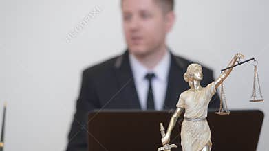 Man and woman consulting with professional lawyer. Themis statue in law office