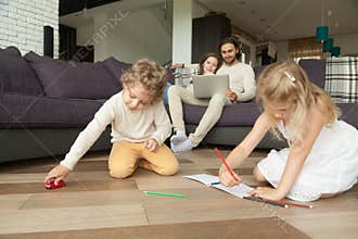 Kids playing drawing at home, family spending leisure time toget