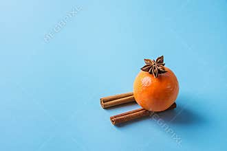 Tangerine on Cinnamon Sticks Imitating Sledges Anise Star Blue Background. Christmas New Year Greeting Card Poster Sales Template.