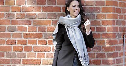 Beautiful woman leaning on brick wall