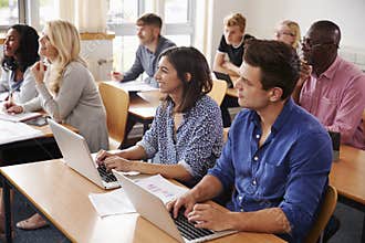 Mature Students Sitting At Desks In Adult Education Class