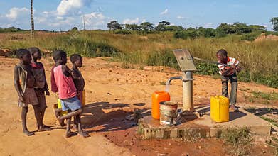 Local African children pumping drinking water at well built by c