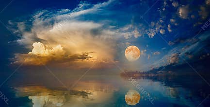 Full moon rising above serene sea in sunset sky