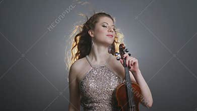 Concert of live music, women playing melody solo on fiddle-bow in flashing light searchlight illumination
