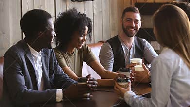 Diverse young guys spending time together in cafe drinking coffee