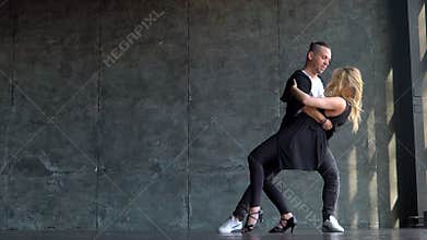 Beautiful couple of professional artists dancing passionate dance. Young couple dancing zouk dance