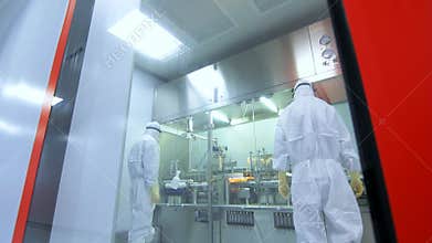 Two pharmaceutical workers control production process. Scientists in laboratory