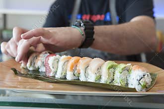 Sushi chef plating a roll of sushi