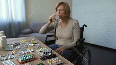 Disable female in wheelchair drinking pills with water, recovery, nursing home