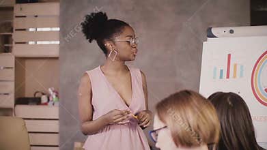 Successful African American female business coach training multiethnic team at corporate training seminar slow motion.