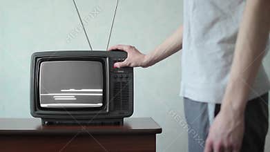 Man switches channels on old TV