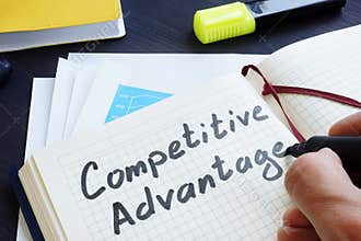 Man is writing words Competitive advantage in the notepad.
