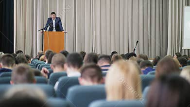 The politician appears on stage in front of an audience