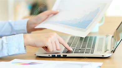 Office worker hands entering data in a laptop