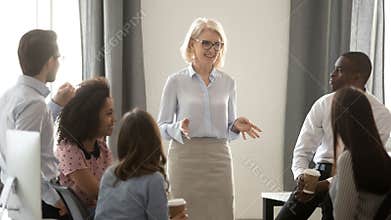 Old woman mentor coach training multicultural interns group in office