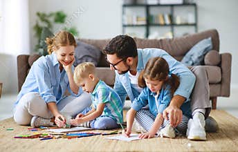 Happy family mother father and kids draw together at home