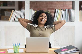 Happy relaxed african american female worker satisfied with finished work