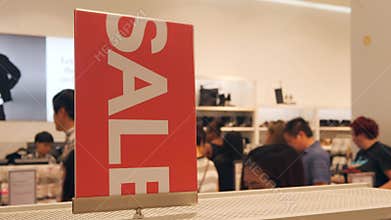 Red Sale Sign and People Queue at Cashier in Clothing Store. Big Christmas Clearance Promotion in Shopping Mall. 4K.