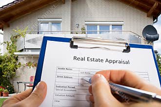 Person Hand Filling Real Estate Appraisal Document