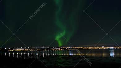 Aurora borealis, northern light over tromso city island and serene autumn fjord