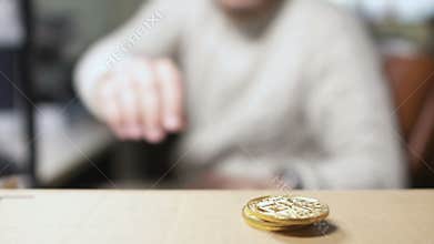 Man takes a bitcoin from a pile