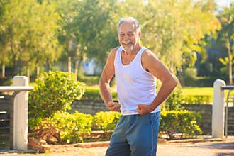 Grey Old Man in Vest Strains Arms Musculars Smiles in Park