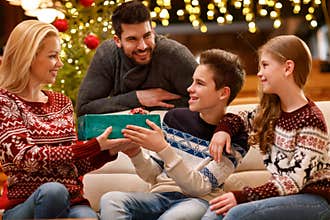 Christmas family together, son give gift to mother