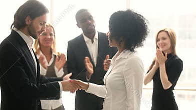 Company boss handshaking african employee, promoting congratulating black young woman