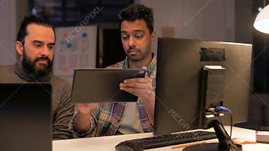 Programmers with tablet pc working at night office