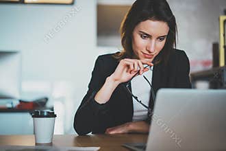 Smiling beautiful businesswoman using laptop computer at modern office.Blurred background.Horizontal.