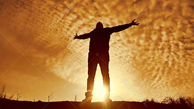 Silhouette of a man with hands raised in the sunset concept for religion, worship, prayer and praise. silhouette of a